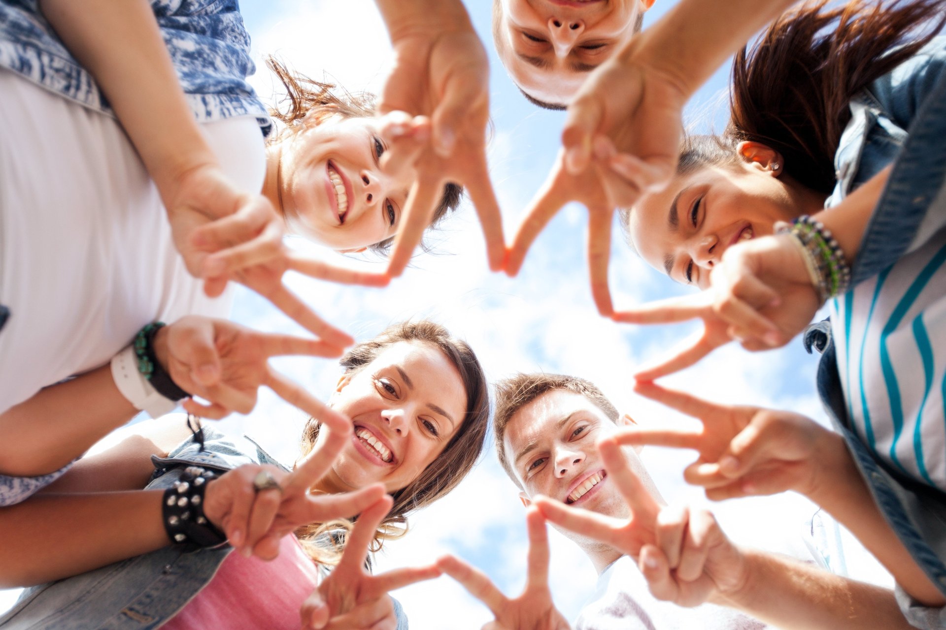 Gruppe von Teenagern, die "Peace-Zeichen" zeigen wurde von unten nach oben fotografiert