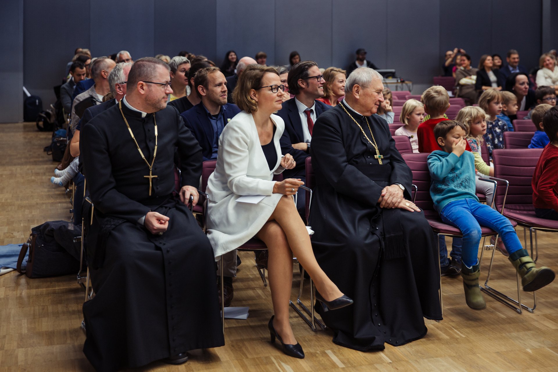Foto vom Saal mit Ehrengästen und vielen Teilnehmerinnen und Teilnehmern